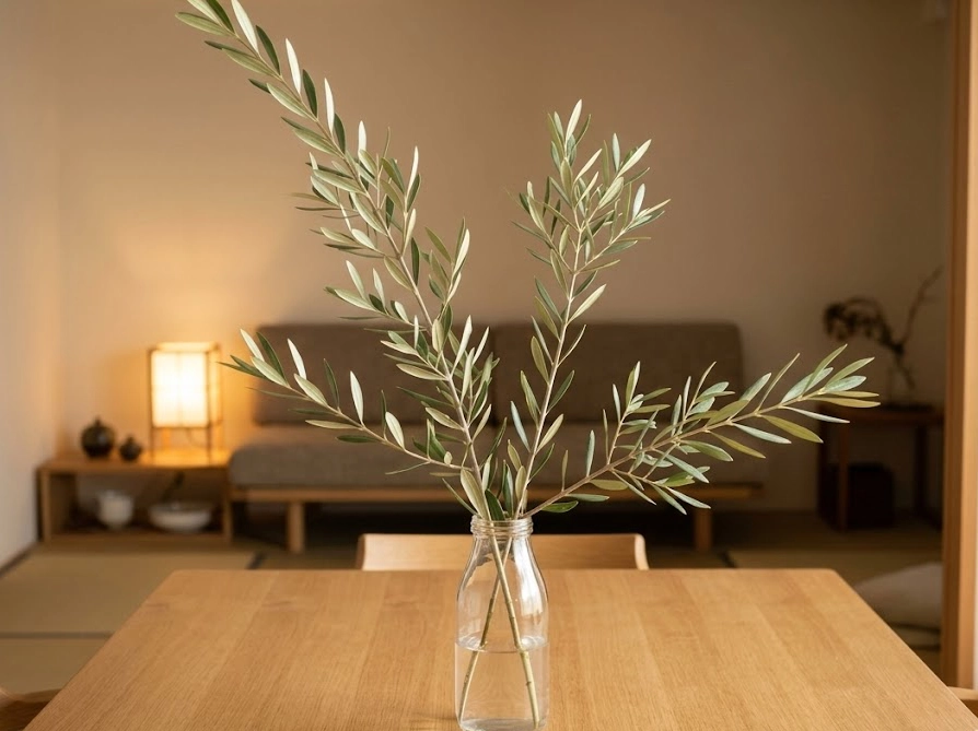 ダイニングテーブルにガラス瓶で高低差をつけて飾ったオリーブの枝