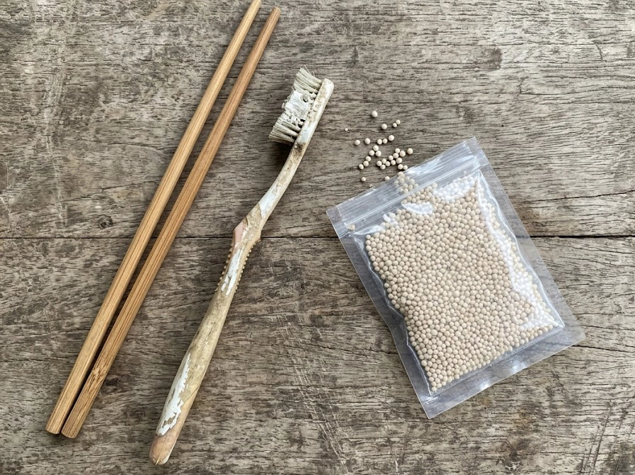 カイガラムシ駆除用の歯ブラシと割り箸とオルトラン粒剤を並べたスマホ撮影風写真