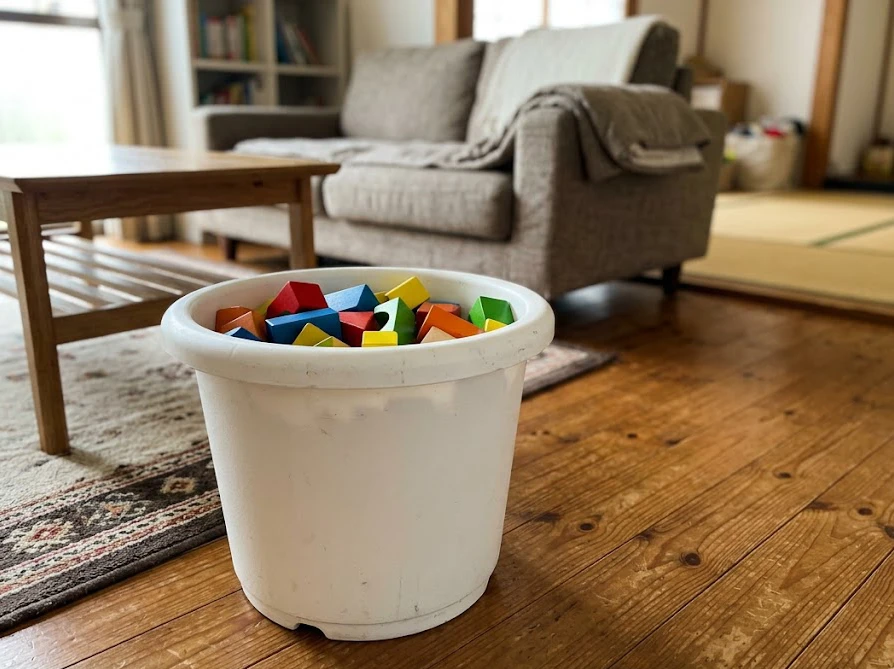 リビングの床に置かれ子供のおもちゃ収納として使われているプラスチック製の植木鉢